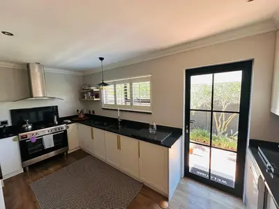 a kitchen with an open door to a patio at Lelani Self Catering Cape Town in Oakdale