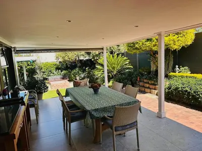 a dining table and chairs on a patio at Lelani Self Catering Cape Town in Oakdale