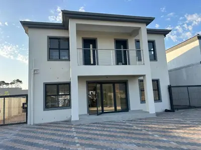 a white house with black windows and a fence at Bokwe's Guest House- Cape Town in Gordonʼs Bay