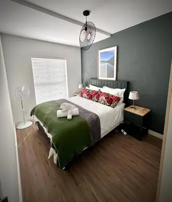 a bedroom with a large bed with red pillows at Splendour on Dorp in Stellenbosch