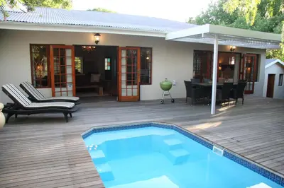 a patio with a swimming pool and a house at Cape Robin Cottage in Franschhoek