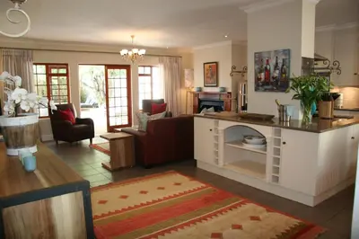 a large living room with a kitchen and a living room at Cape Robin Cottage in Franschhoek