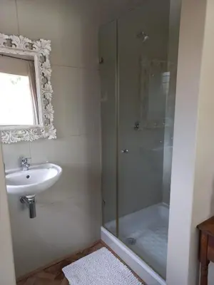 a bathroom with a glass shower and a sink at Spacious Modern Home, Paarl Winelands in Paarl