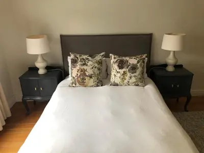 a bedroom with a bed with two nightstands and two lamps at Spacious Modern Home, Paarl Winelands in Paarl