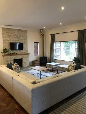 a living room with a large couch and a fireplace at Spacious Modern Home, Paarl Winelands in Paarl