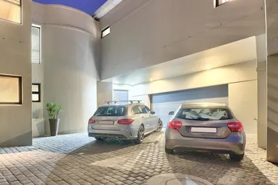 two cars parked in front of a garage at Luxury Mini Villa Sunset Beach Cape Town in Cape Town
