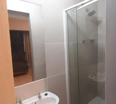 a bathroom with a shower with a toilet and a sink at Apartment in Flamingo Vlei in Cape Town
