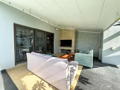 a living room with a couch and a table at Cheap Affordable Self-Catering Double Room with Pool, WiFi and Braai in Cape Town