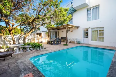 a swimming pool in front of a house at Vermont Dreamcatcher in Hermanus