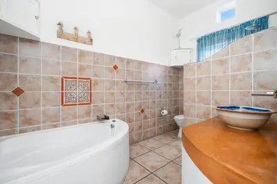 a bathroom with a tub and a toilet and a sink at Vermont Dreamcatcher in Hermanus