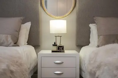 a bedroom with two beds and a lamp on a night stand at Apartments on Century in Cape Town