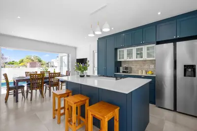 a kitchen with blue cabinets and a table and chairs at Metalasia Four in Bettyʼs Bay