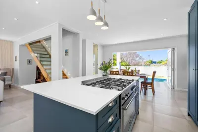 a kitchen with a stove and a dining room at Metalasia Four in Bettyʼs Bay