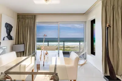 a living room with a view of the ocean at Dolphin Beach Penthouse in Cape Town