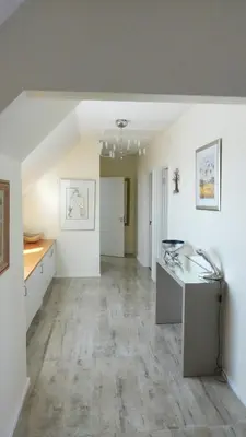 an empty living room with a desk and a hallway at Dolphin Beach Penthouse in Cape Town