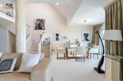 a living room with a couch and a table at Dolphin Beach Penthouse in Cape Town