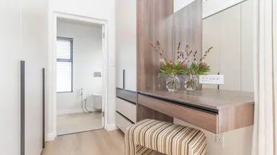 a living room with a console table with flowers on it at Ocean Whisper Villa near Westcliff coastal paths in Hermanus