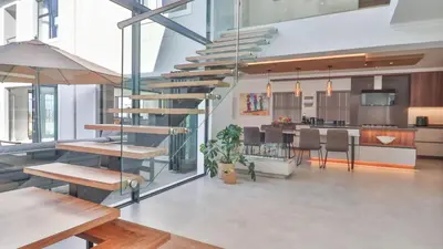 a spiral staircase in a room with a kitchen at Ocean Whisper Villa near Westcliff coastal paths in Hermanus