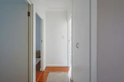 a hallway with white walls and a glass door at Fully Equipped Claremont Home with Pool & Style in Cape Town