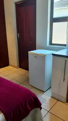a kitchen with a washer and dryer and a window at Overnight Lodge in Cape Town