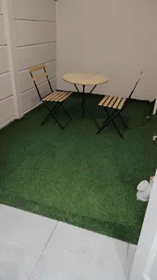 a table and two chairs sitting on a green floor at Kenwyn Micro Cottage in Cape Town