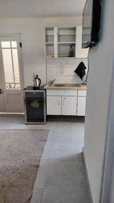 a kitchen with a sink and a stove at Kenwyn Micro Cottage in Cape Town