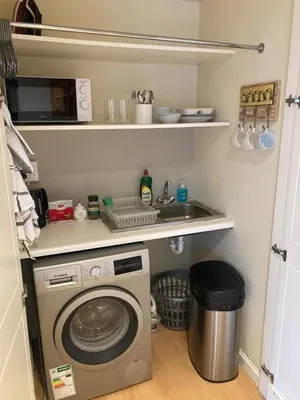 a kitchen with a washing machine and a sink at Cozy garden Guest Suite in charming Claremont in Cape Town