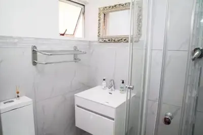 a bathroom with a shower and a toilet and a sink at Fully Furnished Room and en-suite in Cape Town