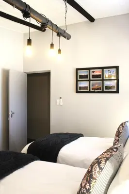 two beds in a room with white walls at Lategansrus at Helpmekaar Farm in Wellington