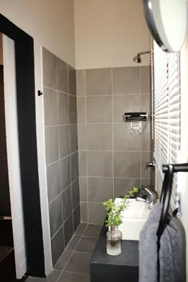 a bathroom with a sink and a shower at Lategansrus at Helpmekaar Farm in Wellington