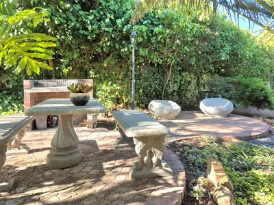 a patio with a table and two chairs and a bench at Mistys Studio Durbanville in Durbanville