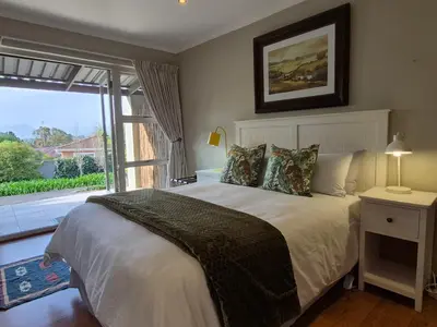 a bedroom with a bed and a large window at Mistys Studio Durbanville in Durbanville