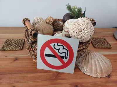 a no smoking sign next to a basket of shells at Stylish Studio in Tableview Stay in Cape Town