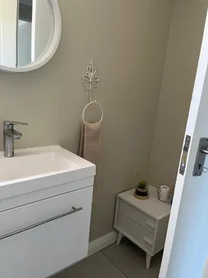 a bathroom with a sink and a mirror at Three on Firmount in Somerset West
