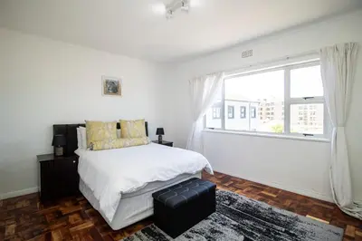 a bedroom with a bed and a large window at Mountain View Coastal Retreat in Strand
