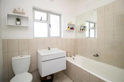 a bathroom with a toilet and a sink and a tub at Mountain View Coastal Retreat in Strand