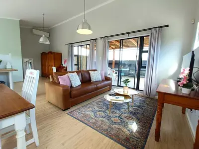 a living room with a couch and a table at Helderberg Hideaway Loft in Somerset West