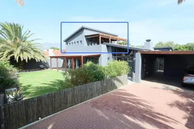 a house with a fence in front of a yard at Helderberg Hideaway Loft in Somerset West