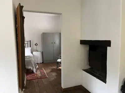 a room with a fireplace and a bed and a mirror at William's Cottage in Franschhoek