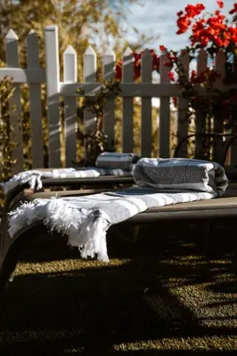 a bench with towels on it in front of a white fence at The Crescent Hideaway in Franschhoek
