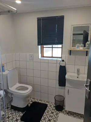 a bathroom with a toilet and a sink at 7th Heaven Guest Cottage in Paarl