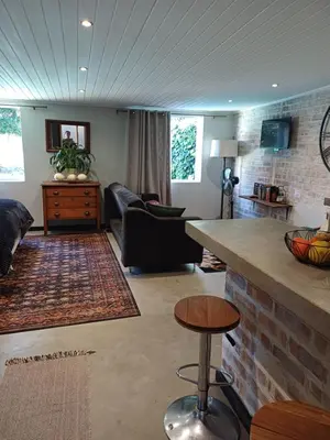 a living room with a couch and a table at 7th Heaven Guest Cottage in Paarl