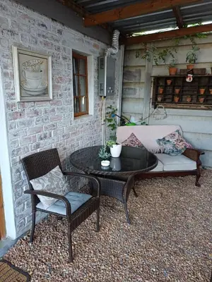 a patio with a couch and a table and chairs at 7th Heaven Guest Cottage in Paarl