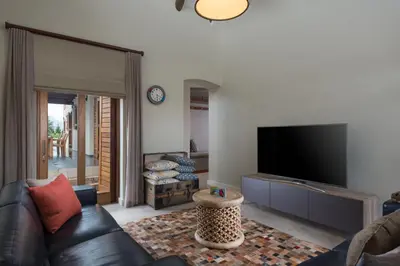 a living room with a couch and a flat screen tv at Skaap huis in Sir Lowryʼs Pass