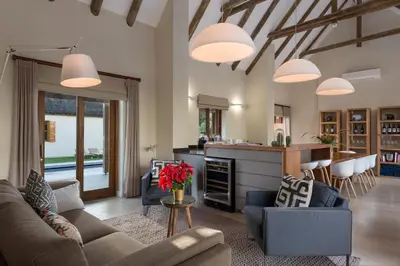 a living room with a couch and chairs and a kitchen at Skaap huis in Sir Lowryʼs Pass