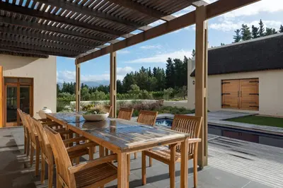 a wooden table and chairs on a patio at Skaap huis in Sir Lowryʼs Pass