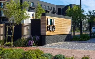 a building with a sign that reads pinks at Luxe at Nine Palms Near Canal Walk in Cape Town