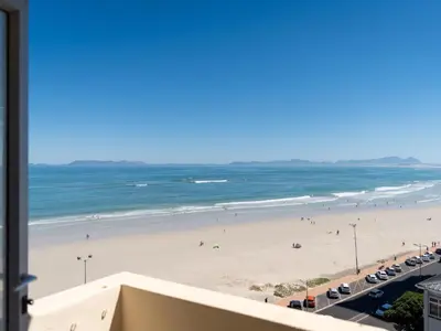 a view of the beach from the balcony of a condo at Romilly Beachfront 92 in Strand