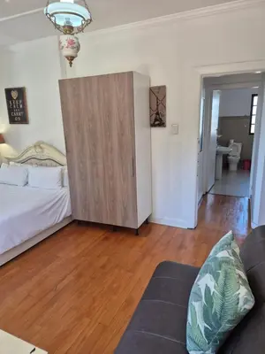 a living room with a bed and a sliding door at Pine House - self-catering in Cape Town
