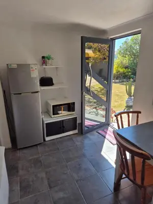 a kitchen with a refrigerator and a table at Pine House - self-catering in Cape Town